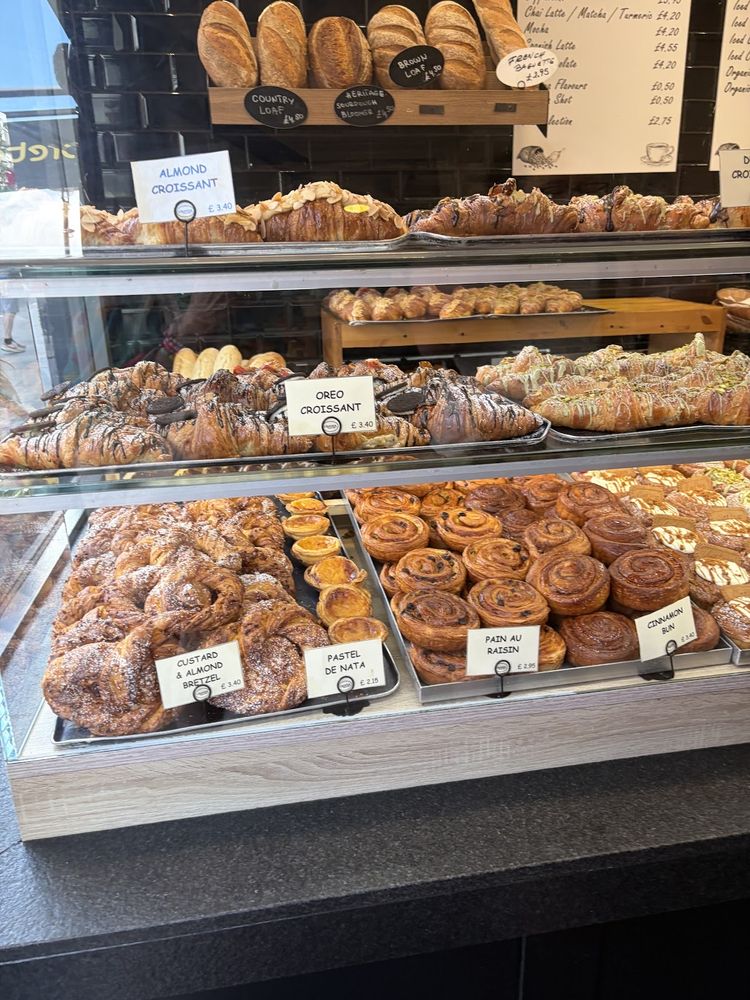 Shelves packed with croissants, danishes and cinnamon rolls under the bread racks