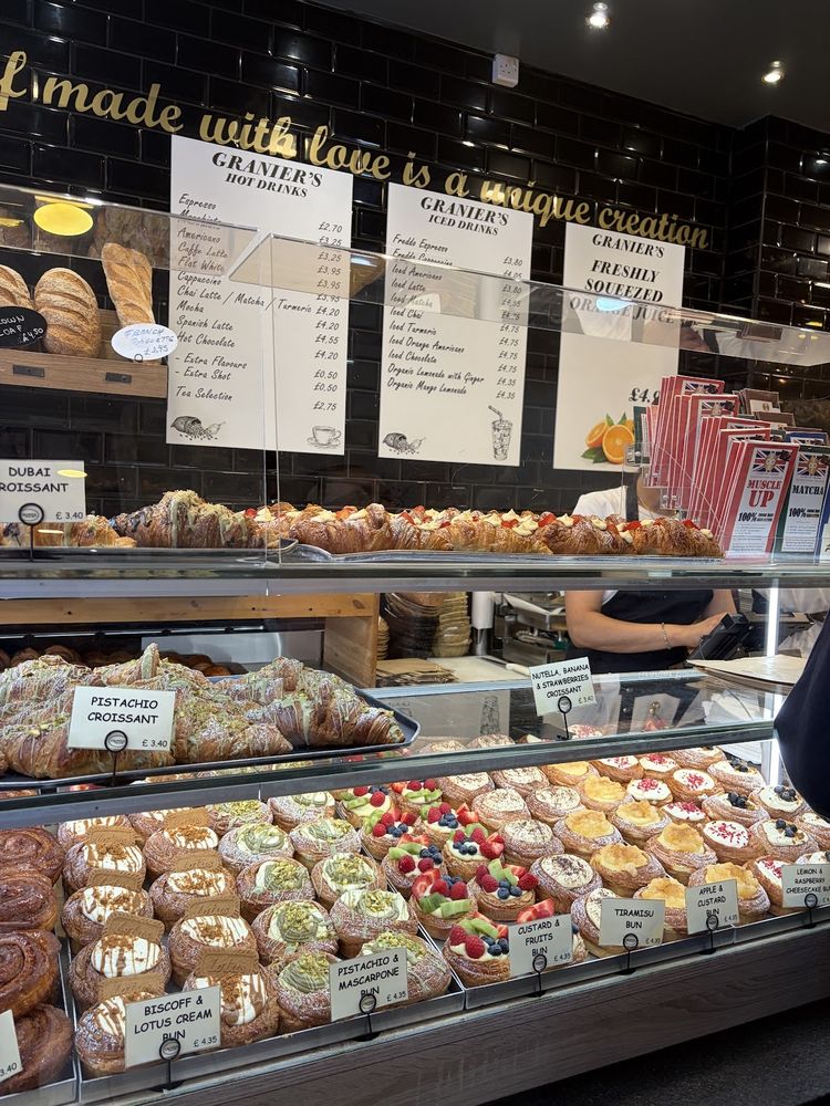 The counter and display cabinet full of pastries and cakes